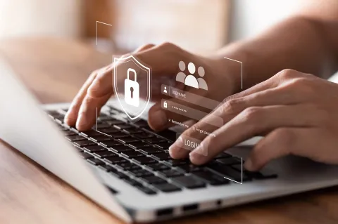 Hands typing on laptop