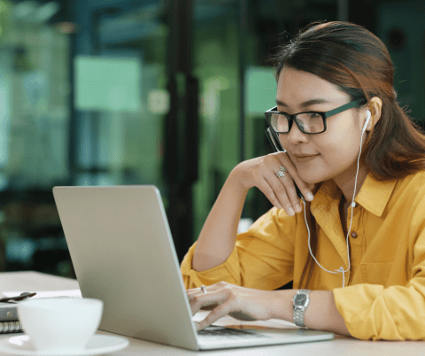Woman training sitting at laptop with earbuds
